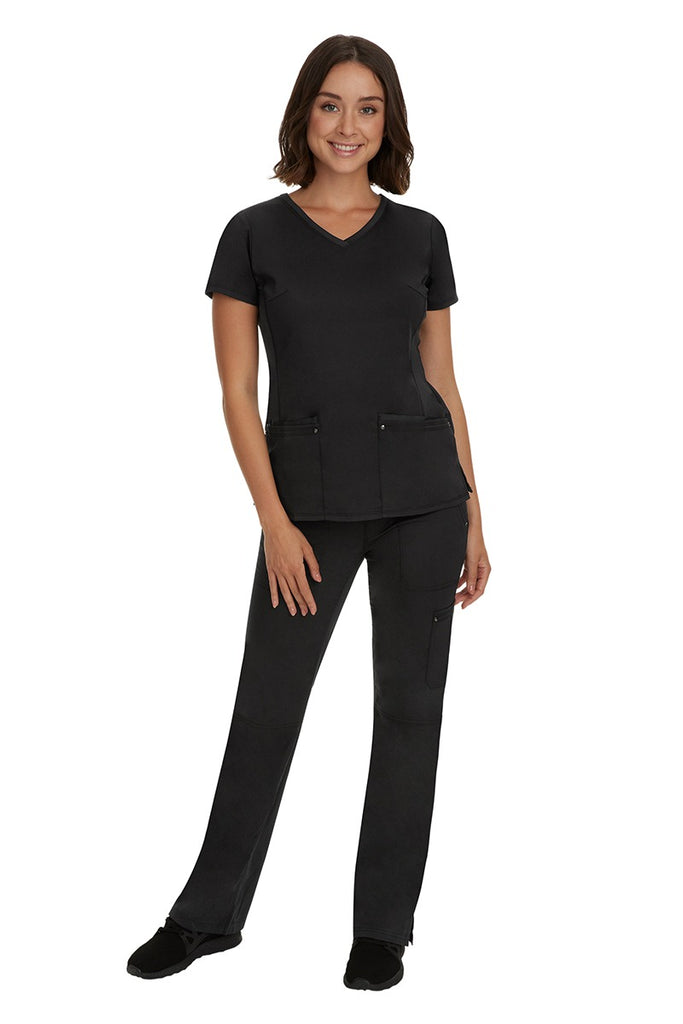 A young female nurse wearing a Purple Label Women's Juliet Yoga Scrub Top by Healing Hands in Black featuring a v-neckline.