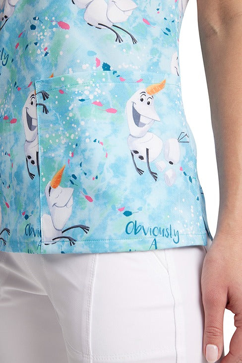 A young LPN wearing a Tooniforms Women's V-Neck Print Scrub Top in "Obviously a Unicorn" featuring contrast piping throughout for a flattering fit.