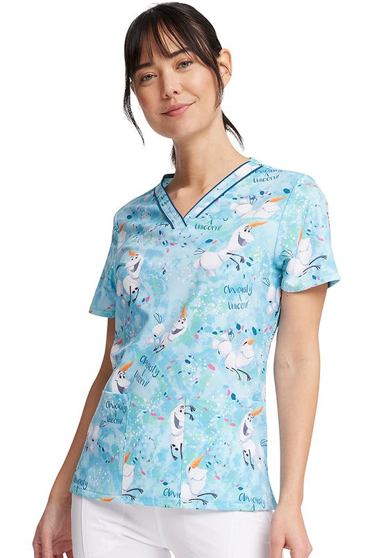 A young woman wearing a Cherokee Tooniforms Women's V-Neck Print Scrub Top in "Obviously a Unicorn" featuring 2 front patch pockets.