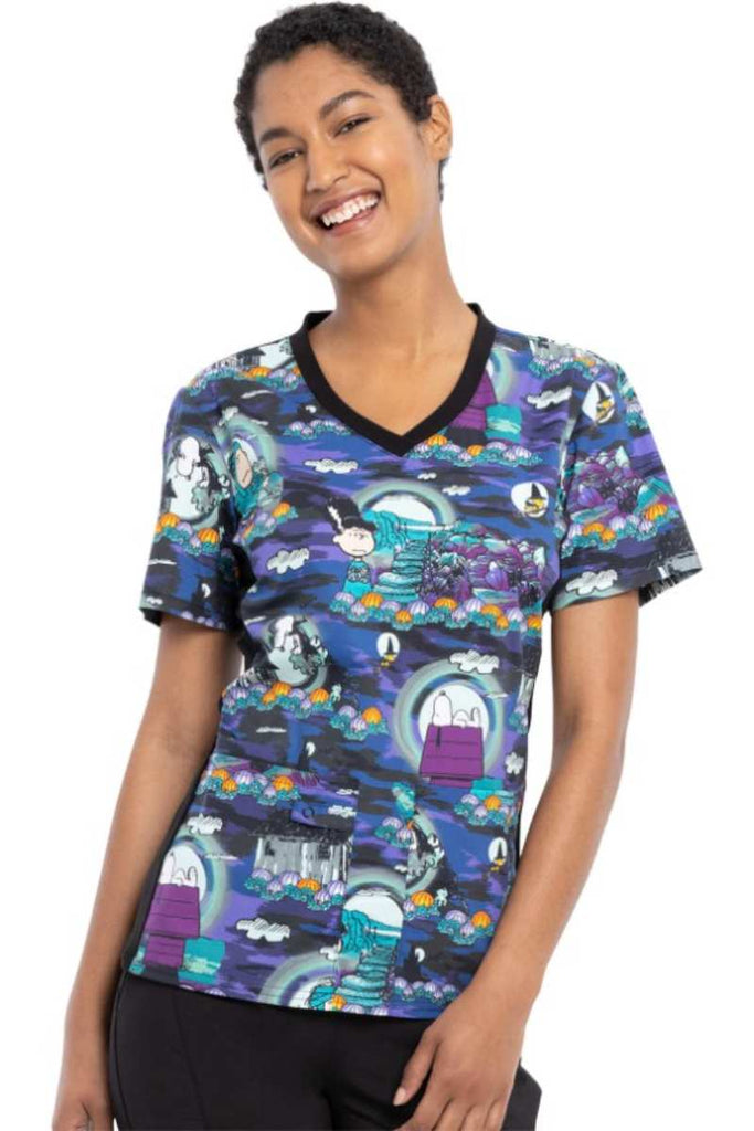 A young female CNA wearing a Tooniforms Women's V-neck Knit Panel Print Top in "Midnight Pumpkin" featuring a modern classic ift. 