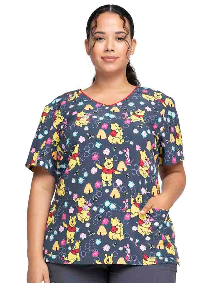 Female healthcare worker wearing a Tooniforms Women's V-Neck Print Scrub Top in "Bee's Knees" featuring a modern classic fit.