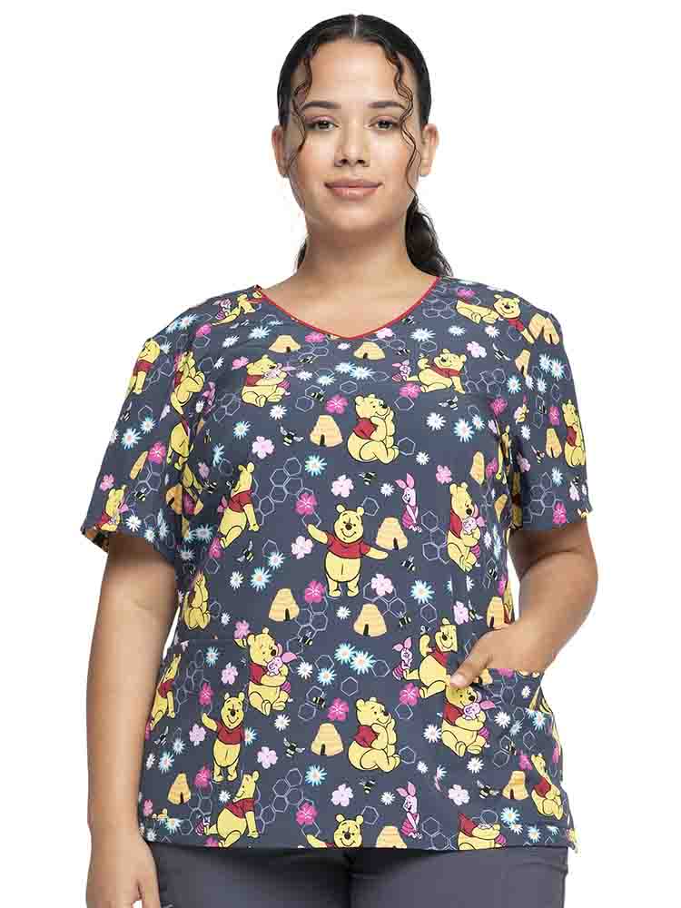 Female healthcare worker wearing a Tooniforms Women's V-Neck Print Scrub Top in "Bee's Knees" featuring a modern classic fit.