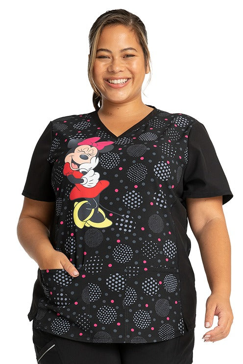 A young female CNA wearing a Women's Stylized V-Neck Print Top from Cherokee Tooniforms in "Minnie Spotlight".