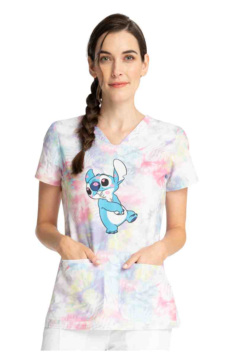 A young female Physician wearing a Tooniforms Women's Shaped V-neck Print Top in "Stitch Smooches" size large featuring 2 front patch pockets.