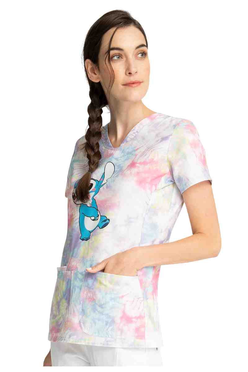 A young female LPN wearing a Tooniforms Women's Shaped V-neck Print Top in "Stitch Smooches" size XS featuring 1 interior pocket on the wearer's right side. 