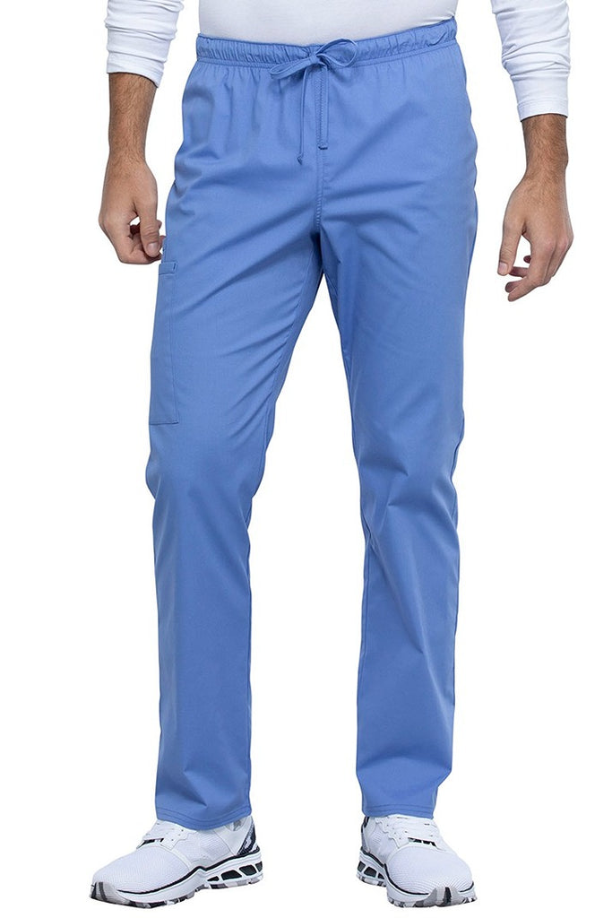 A picture of a male Nurse Practitioner wearing a Cherokee Unisex Straight Leg Scrub Pant in Ceil size Medium Tall featuring a Bi-Stretch, durable fabric.