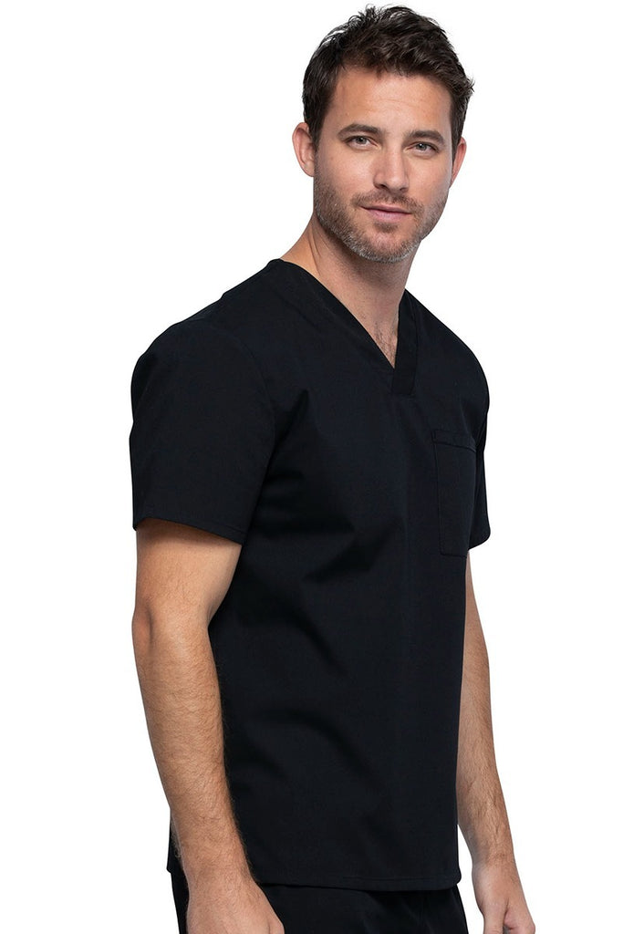 A young male Psychiatric Aide wearing a Cherokee Unisex Tuckable V-neck Scrub Top in Black size Medium featuring one front chest pocket with a pen stitch on the wearer's left side.