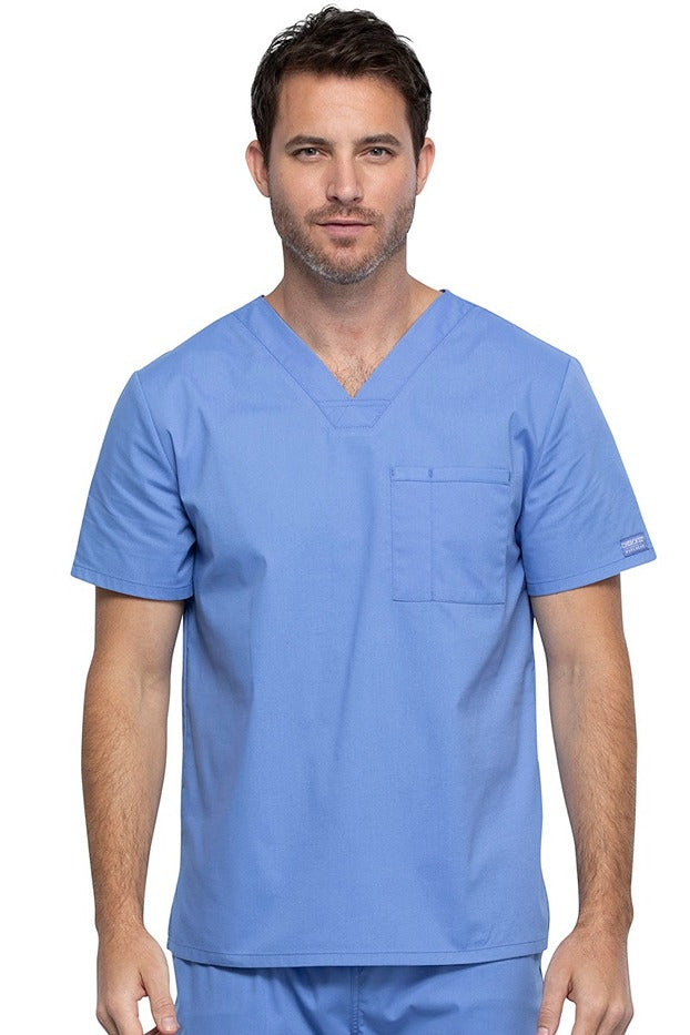 A middle aged Male Physician wearing a Cherokee Unisex Tuck-in V-neck Scrub Top in Ceil Blue size XL featuring 1 front chest pocket.