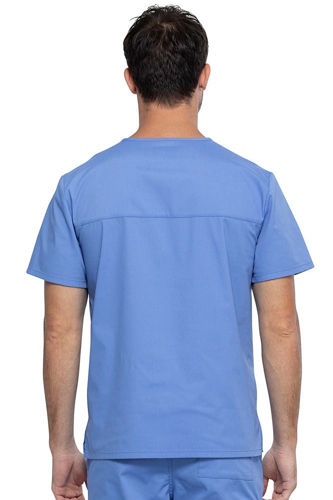 An image of a Male Medical Assistant wearing a Cherokee Unisex Tuckable V-neck Scrub Top in Ceil Blue size 3XL featuring a back yoke & dolman sleeves.