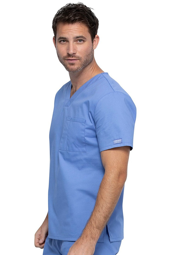 A picture of a young Male Phlebotomist wearing a Cherokee Unisex Tuckable V-neck Scrub Top in Ceil Blue size Large featuring pull-on closure.