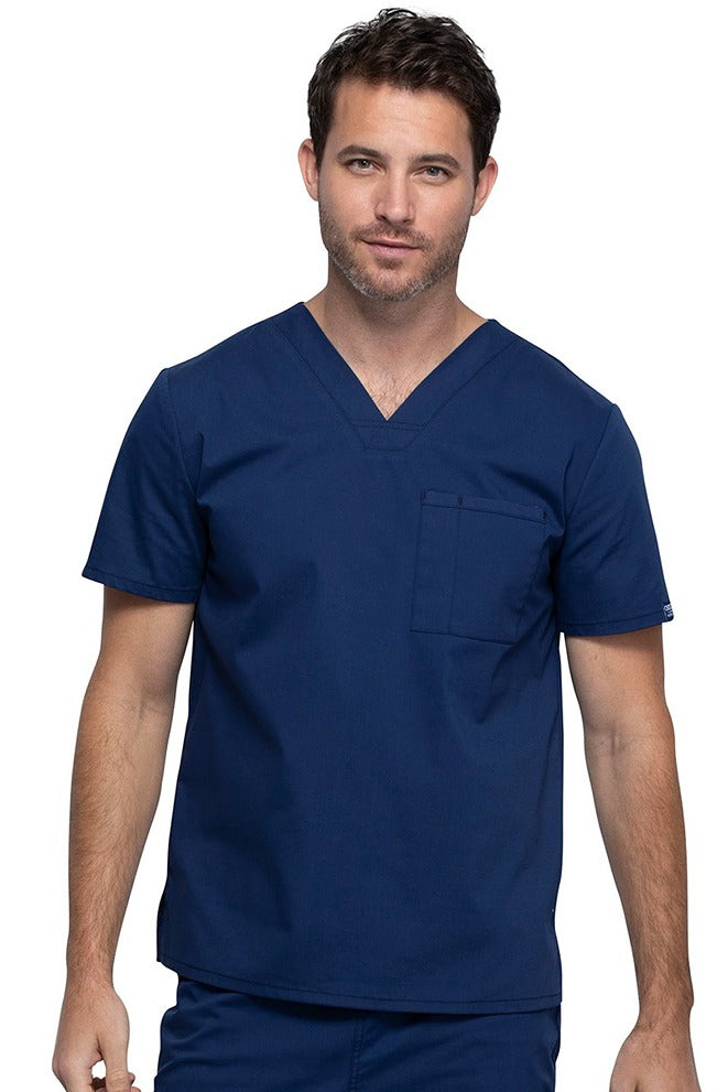 A middle aged Male Physician wearing a Cherokee Unisex Tuck-in V-neck Scrub Top in Navy size XL featuring 1 front chest pocket.