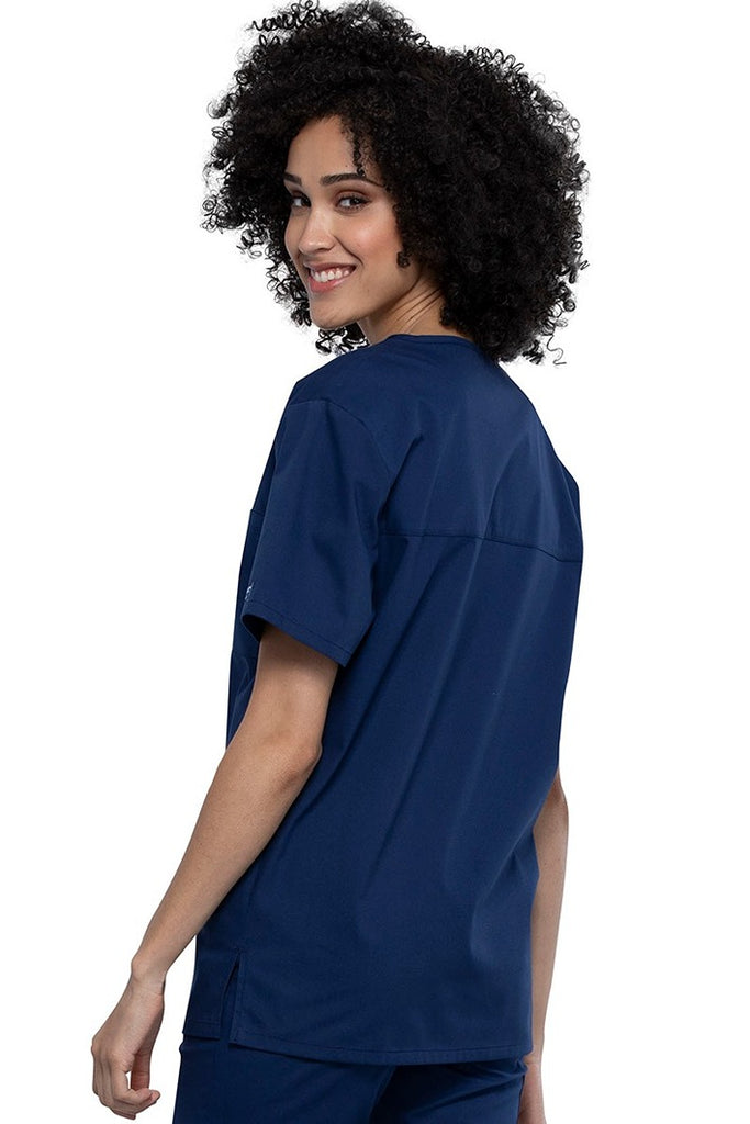 An image of a Female Physician wearing a Cherokee Unisex Tuck-in Scrub Top in Navy size Medium featuring a center back length of 28".