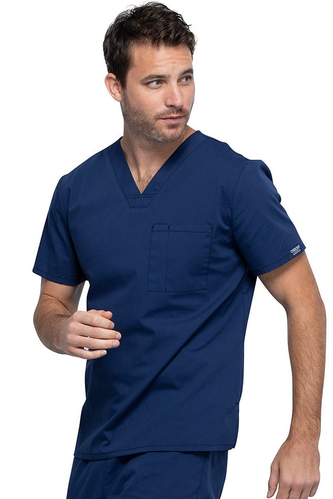 A picture of a young Male Phlebotomist wearing a Cherokee Unisex Tuckable V-neck Scrub Top in Navy size Large featuring pull-on closure.