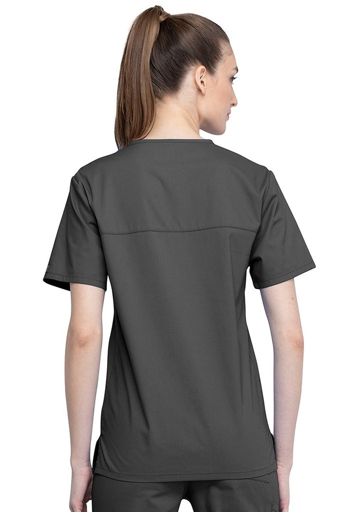 An image of a Female Physician wearing a Cherokee Unisex Tuck-in Scrub Top in Pewter size Medium featuring a center back length of 28".