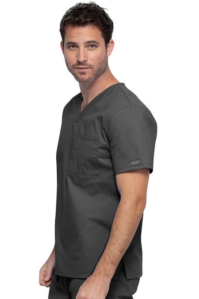 A picture of a young Male Phlebotomist wearing a Cherokee Unisex Tuckable V-neck Scrub Top in Pewter size Large featuring pull-on closure.