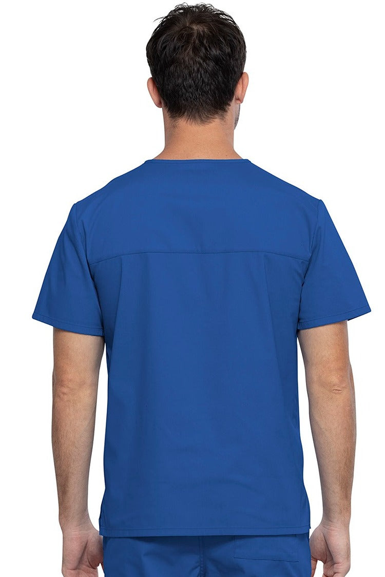 An image of a Male Medical Assistant wearing a Cherokee Unisex Tuckable V-neck Scrub Top in Royal size 3XL featuring a back yoke & dolman sleeves.