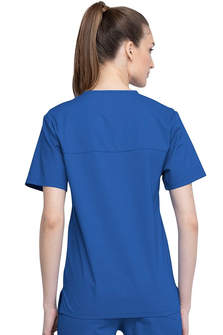 An image of a Female Physician wearing a Cherokee Unisex Tuck-in Scrub Top in Royal size Medium featuring a center back length of 28".