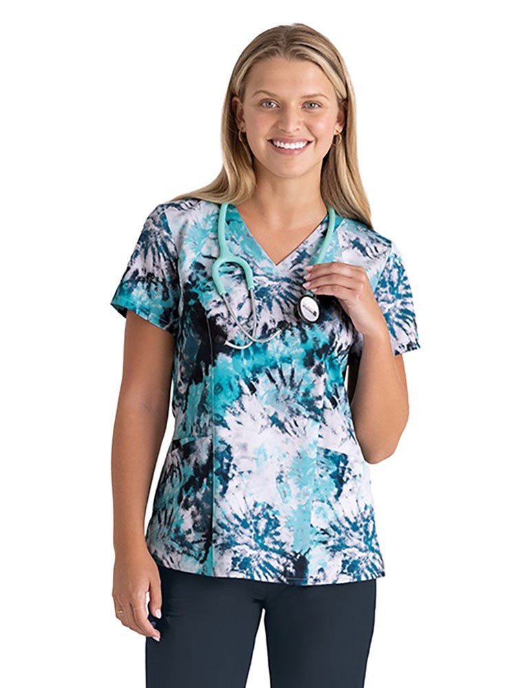 Young nurse wearing a Barco One Women's Print V-Neck Scrub Top in Caribbean Dreams featuring ArcGreen recycled, easy-care fabric for peace of mind that you've made an Eco-friendly choice!