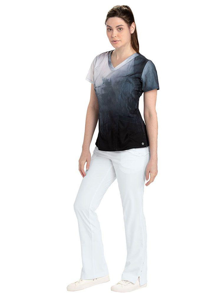 Vet Tech wearing Barco One Women's Print V-Neck Scrub Top in Thermal Springs print & white pants