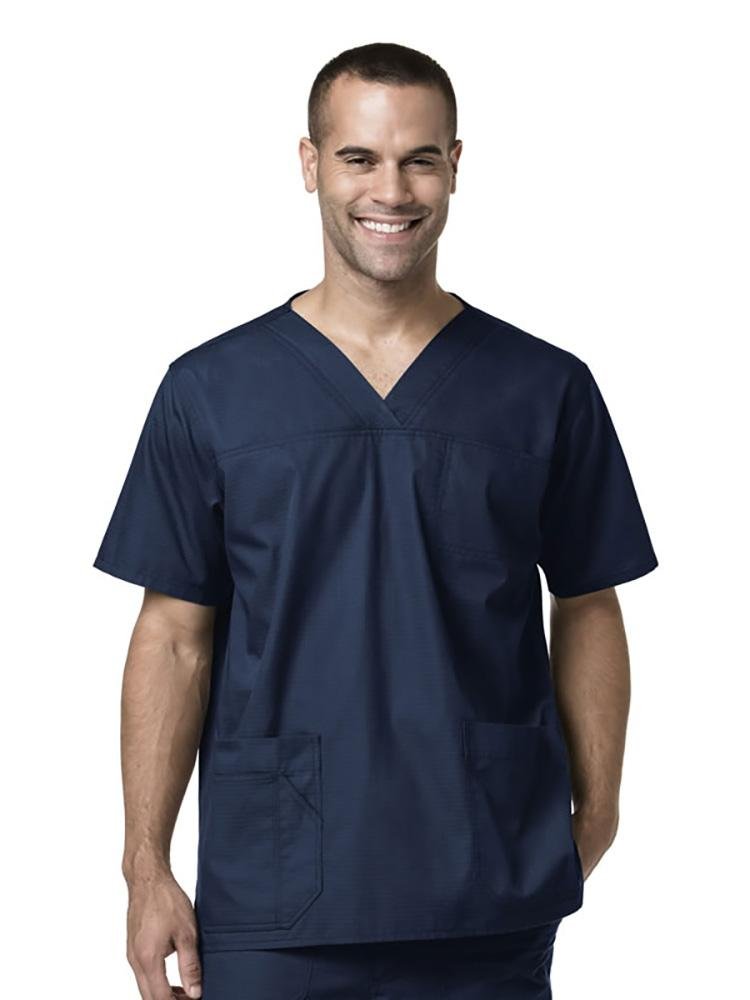 A male Caretaker wearing Carhartt men's Ripstop Multi-Pocket Scrub Top in navy size medium featuring side vents at the hem to keep the wearer cool & comfortable all day.