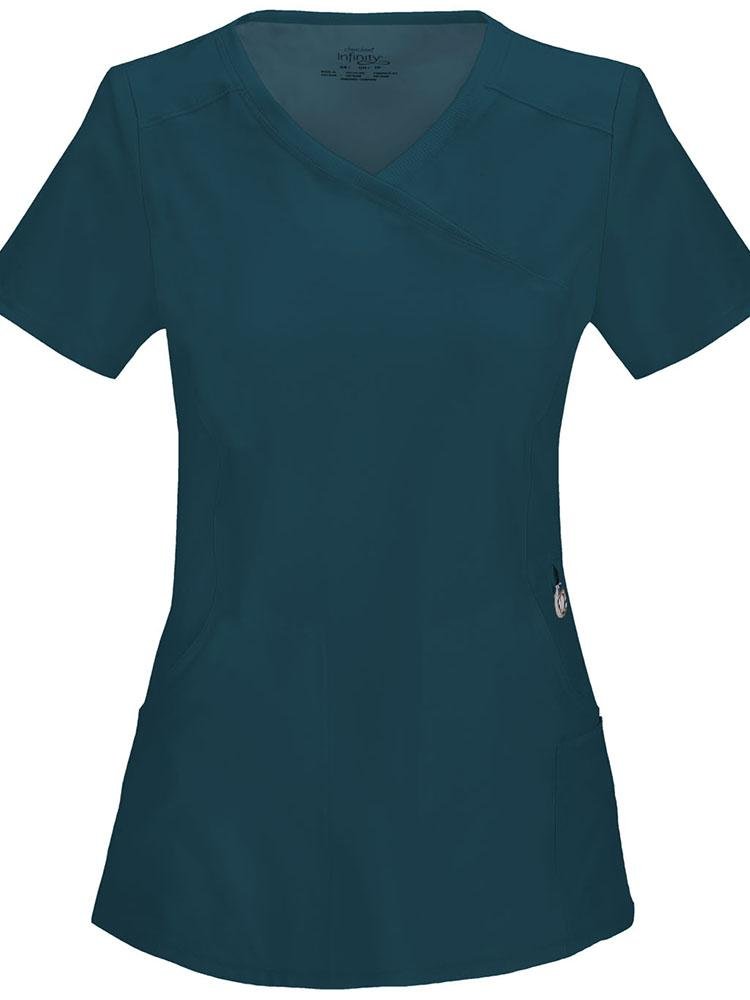 A frontward facing image of the Cherokee Infinity Women's Antimicrobial Mock Wrap Top in Caribbean size small featuring a logo O-ring above left pocket.