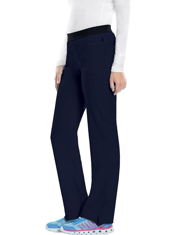 A young female Nurse Practitioner wearing a Cherokee Infinity Women's Low-Rise Slim Pull On Scrub Pant in Navy size Small Tall featuring an elastic waistband.