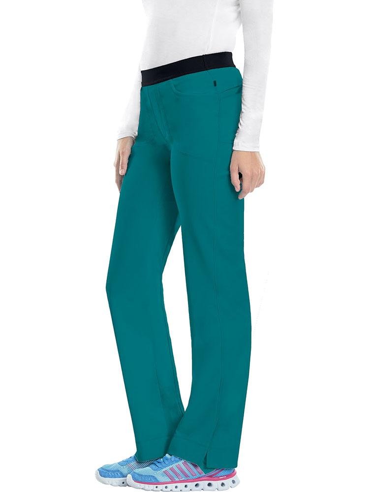 A young female Dental Hygienist wearing a Cherokee Infinity Women's Low-Rise Slim Pull On Scrub Pant in Teal size Medium featuring an elastic waistband.