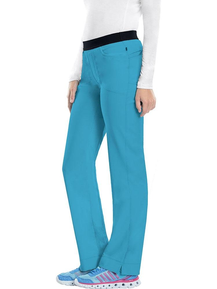 A young female Radiologic Technologist wearing a Cherokee Infinity Women's Low-Rise Slim Pull On Scrub Pant in Turquoise size Medium Tall featuring an elastic waistband.