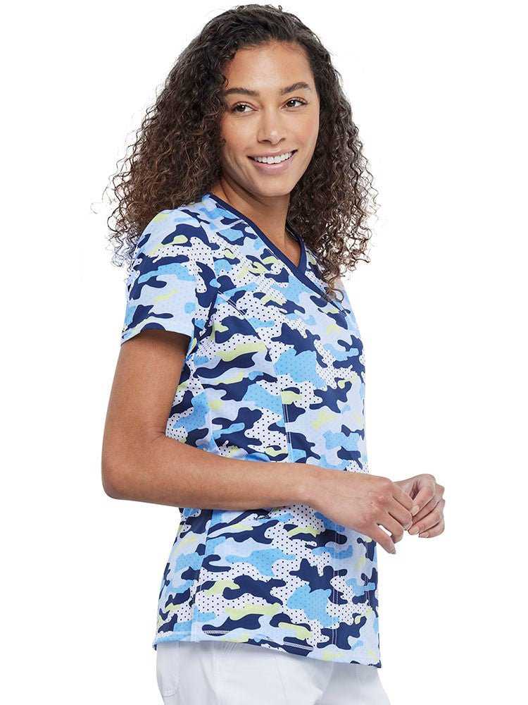 Young woman wearing a Women's Mock Wrap Print Top in Polka Dot Camo featuring front & back princess seams.