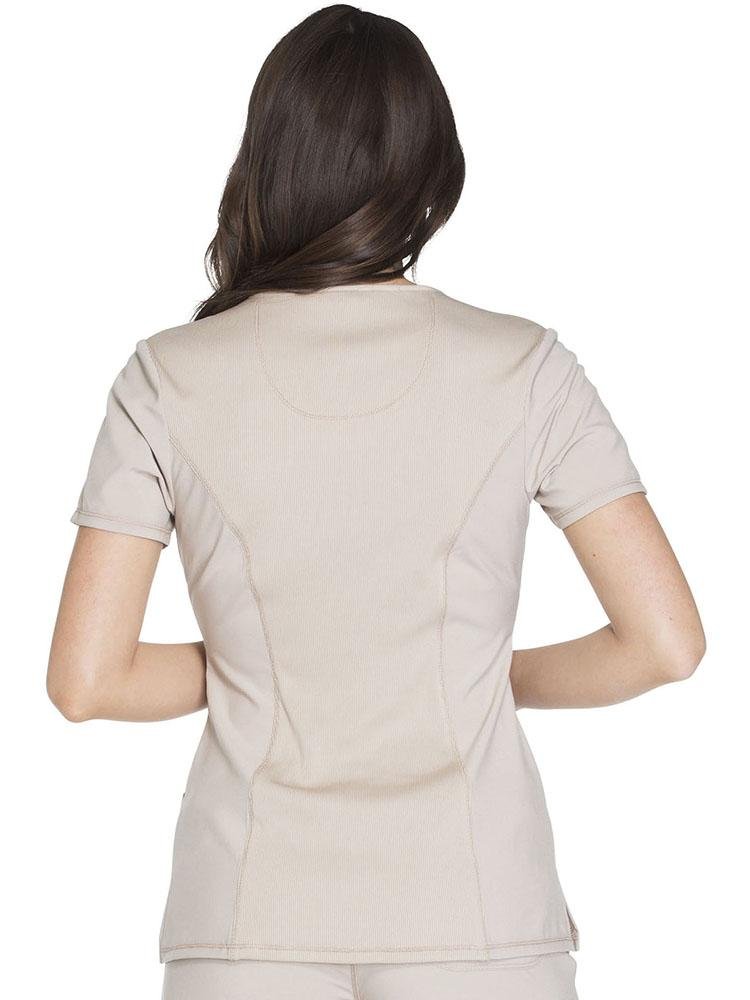 A female Pharmacy Technician wearing a  Cherokee Infinity Women's Round Neck Scrub Top in khaki size XS featuring a stretch rib knit back panel for added movement.