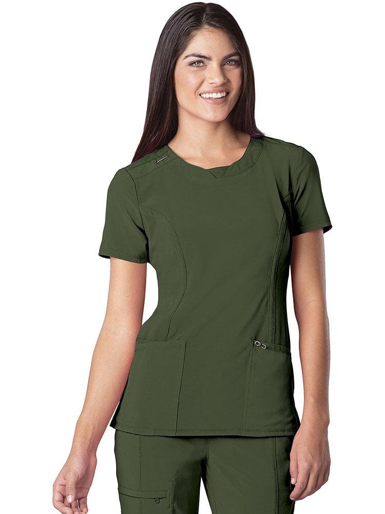 A young female Dental Assistant wearing a Cherokee Infinity Women's Round Neck Scrub Top in Olive size small featuring  2 front patch pockets & 1 interior pocket on the wearer's right side.