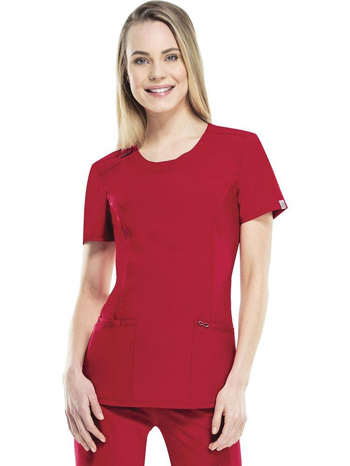 A female Home Health Care Aide wearing a Cherokee Infinity Women's Round Neck Scrub Top in Red size XS featuring a rib knit inset at the front neckband.