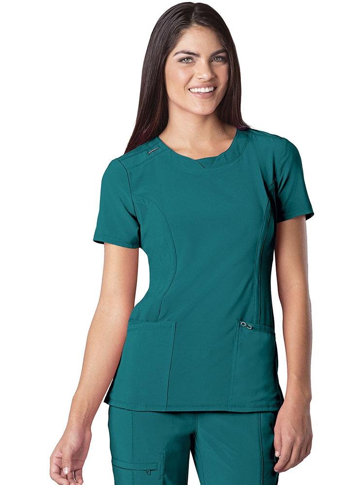 A female Clinical Laboratory Technician wearing a Cherokee Infinity Women's Round Neck Scrub Top in Teal size Medium featuring a rib knit inset at the front neckband.