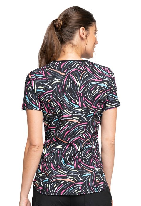 Young woman wearing a Women's V-Neck Print Top from Cherokee Infinity in "Glowing for It" featuring back princess seams.