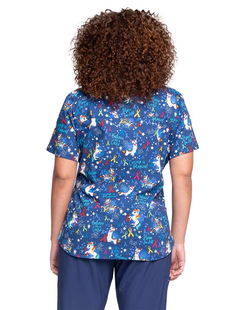 Female nurse wearing a Women's V-Neck Print Scrub Top from Cherokee in "Magical Care" featuring a back yoke & side vents for additional mobility.