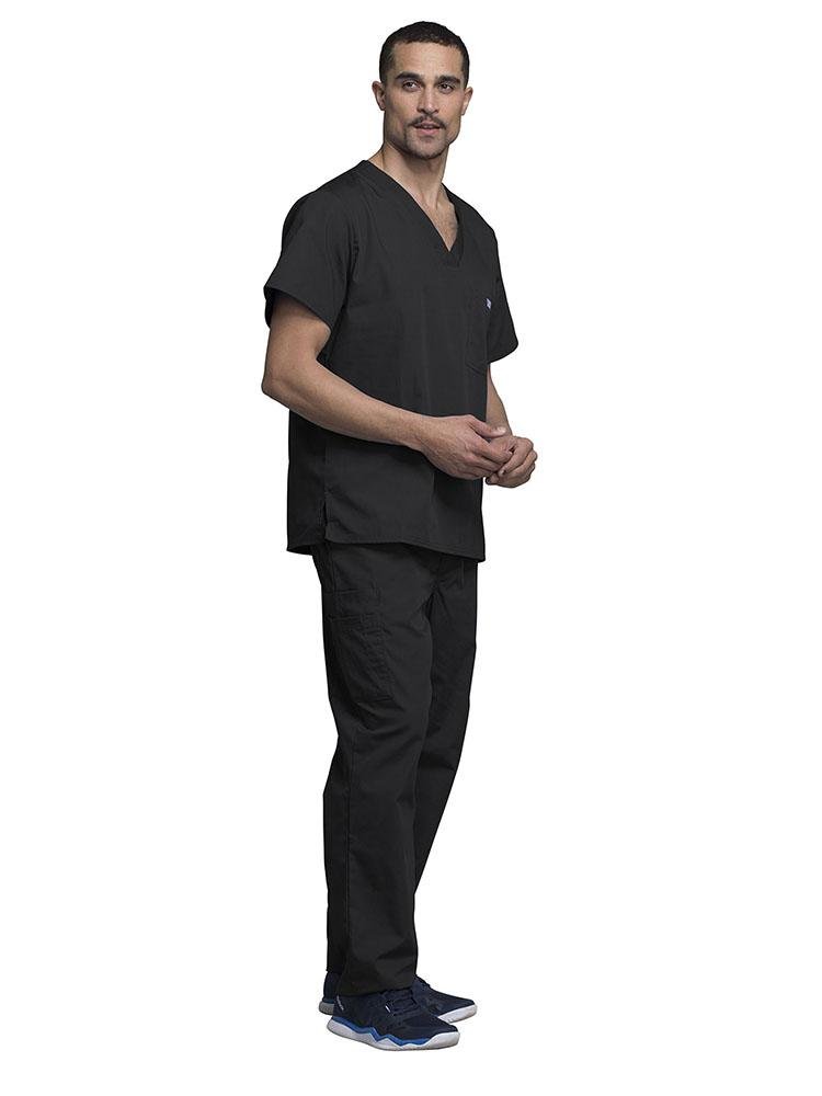 A young male Medical Assistant wearing a Cherokee Workwear Originals Men's Solid V-neck Scrub Top in "Black" size 2Xl featuring side vents for additional range of motion throughout the day.