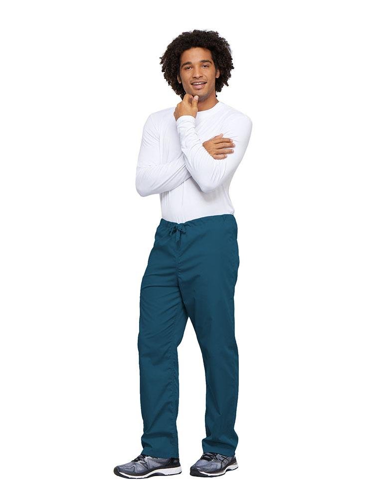 A young male Nurse wearing a Cherokee Workwear Unisex Drawstring Cargo Pant in Caribbean size 4XL featuring an inseam of 31".
