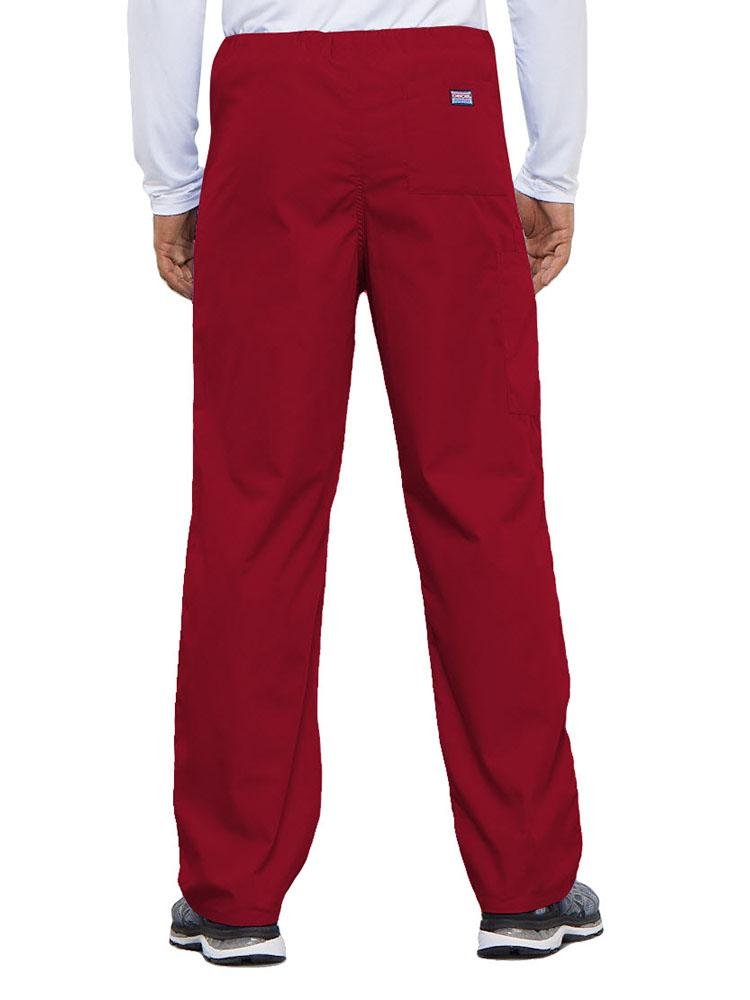 A young male Physical Therapist wearing a Cherokee Workwear Originals Unisex Drawstring Cargo Scrub Pant in Red featuring 1 back pocket.