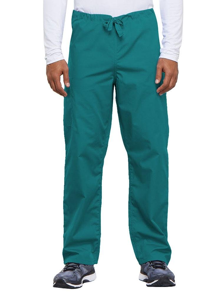 A young male Nurse Practitioner wearing a Cherokee Workwear Originals Unisex Drawstring Cargo Scrub Pant in Teal size Medium Short featuring a total of 3 pockets.