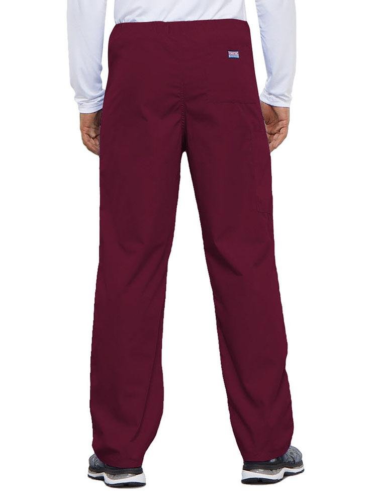 A young male Physical Therapist wearing a Cherokee Workwear Originals Unisex Drawstring Cargo Scrub Pant in Wine featuring 1 back pocket.