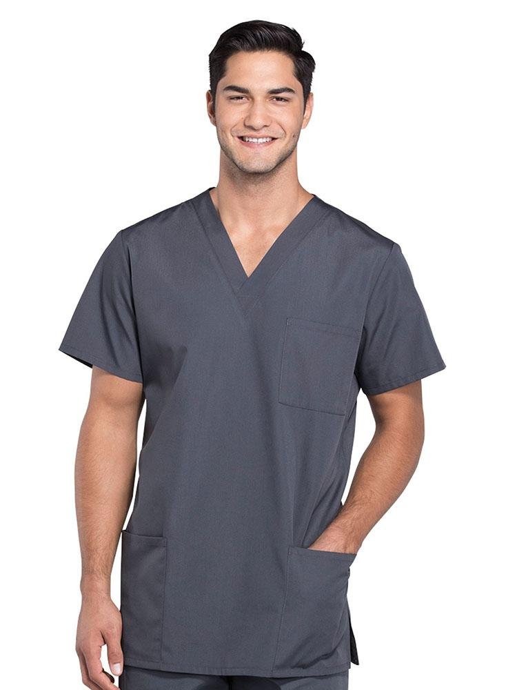 A young male Nurse Practitioner wearing a Cherokee Workwear Originals Unisex Multi-Pocket V-neck Scrub Top in Pewter size 3XL featuring 2 front patch pockets.