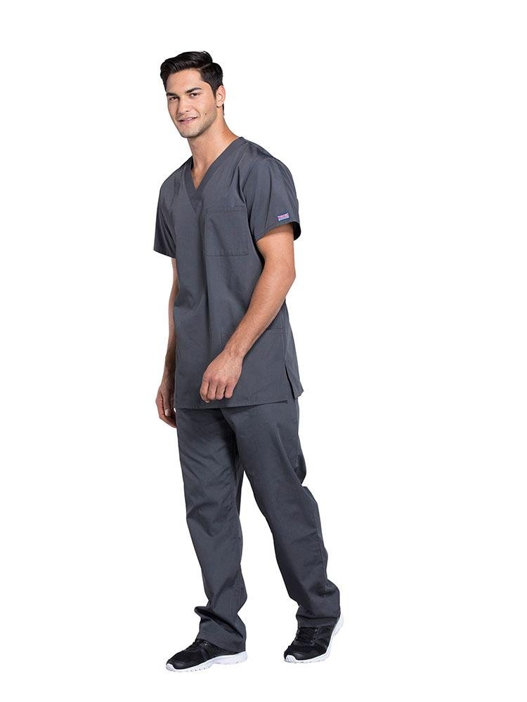 A young male EMT wearing a Cherokee Workwear Originals Unisex Multi-Pocketed V-neck Scrub Top in Pewter size XL featuring side slits for additional mobility throughout the day.