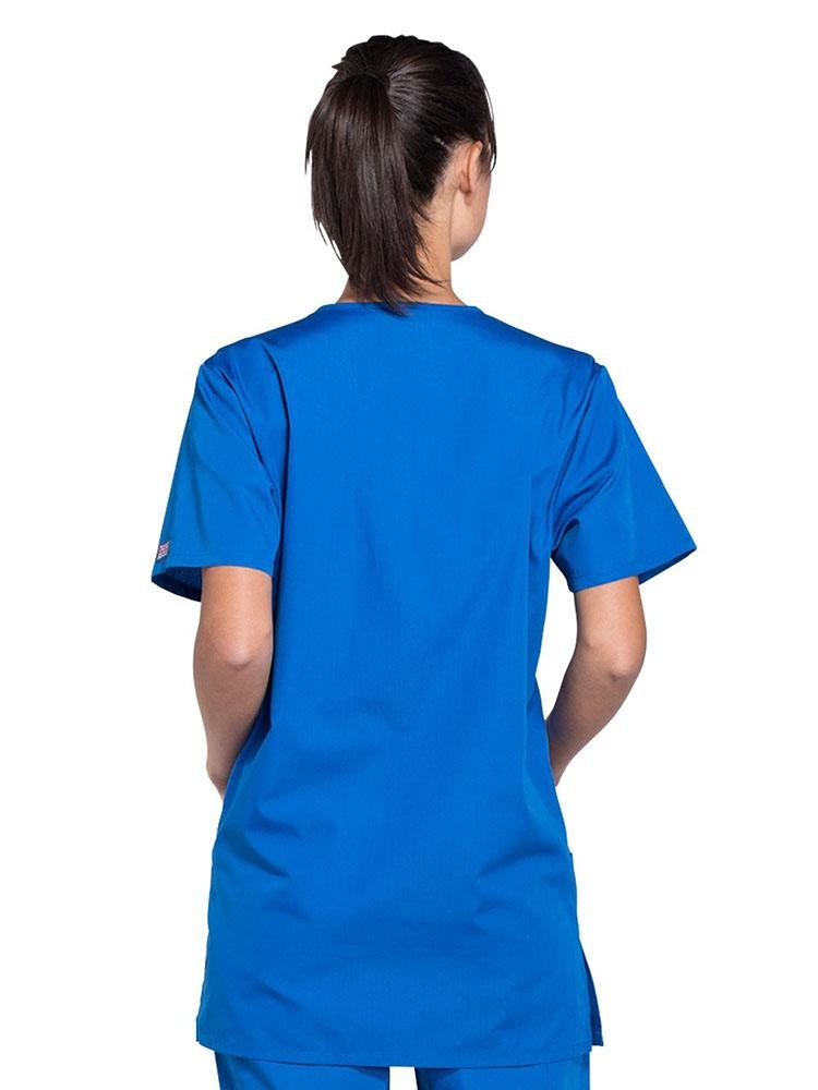 A female Radiologic Technologist showing the back of a Cherokee Workwear Originals Unisex Multi-pocket V-neck Scrub Top in Royal size Large featuring a center back length of 29".