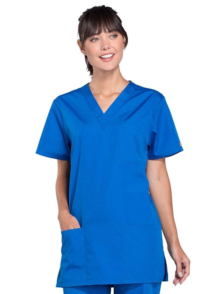 A young female Medical Assistant wearing a Cherokee Workwear Originals Unisex Multi-Pocket V-neck Scrub Top in Royal size 3XL featuring 2 front patch pockets.