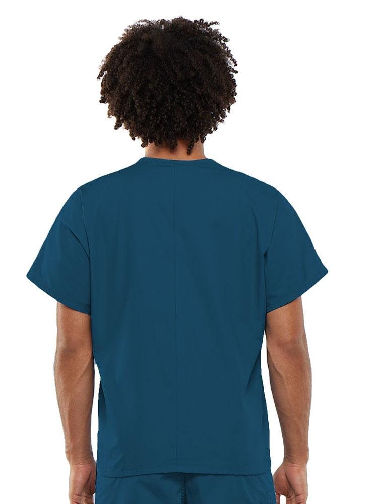 A young male Clinical Laboratory Technician wearing a Cherokee Workwear Originals Unisex Single Pocket V-neck Scrub Top in Caribbean size Large featuring a center back length of 27.5".
