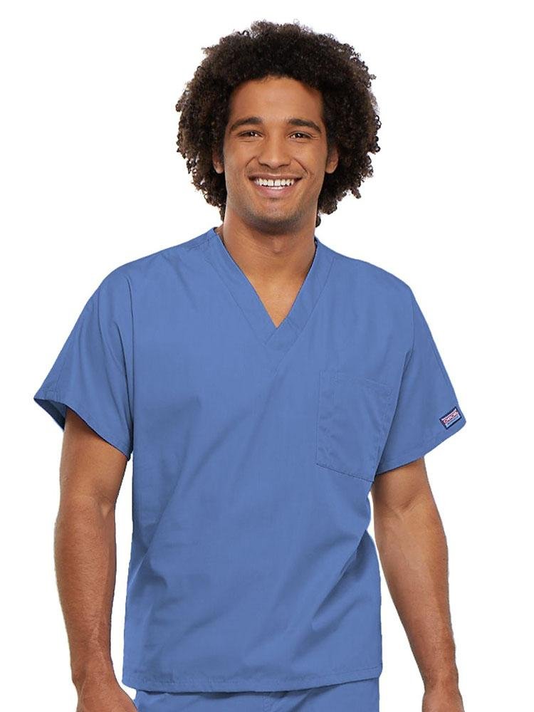 A young male Physician's Assistant wearing a Cherokee Workwear Originals Unisex Single Pocket V-neck Scrub Top in Ceil size 4XL featuring short sleeves.
