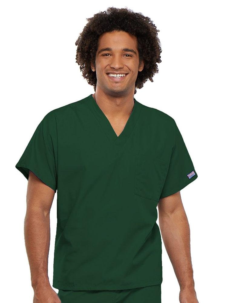 A young male Pharmacist wearing a Cherokee Workwear Originals Unisex Single Pocket V-neck Scrub Top in Hunter Green size 4XL featuring short sleeves.