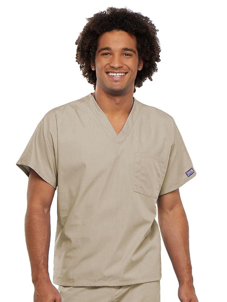 A young male Physician's Assistant wearing a Cherokee Workwear Originals Unisex Single Pocket V-neck Scrub Top in Khaki size 4XL featuring short sleeves.