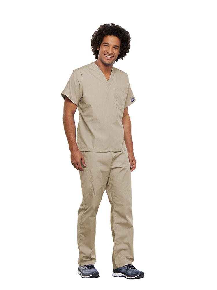 A male Surgical Technician wearing a Cherokee Workwear Originals unisex Single Pocket V-Neck Scrub Top in Khaki size 5XL featuring 1 spacious chest pocket.