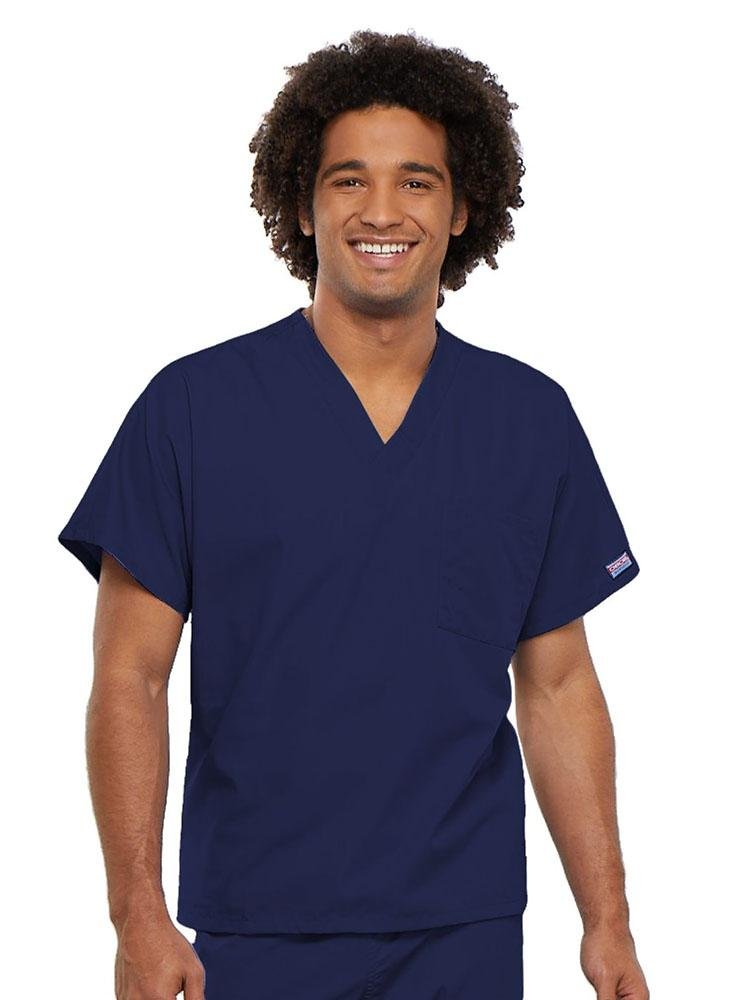 A young male Physical Therapist wearing a Cherokee Workwear Originals Unisex Single Pocket V-neck Scrub Top in Navy size 4XL featuring short sleeves.